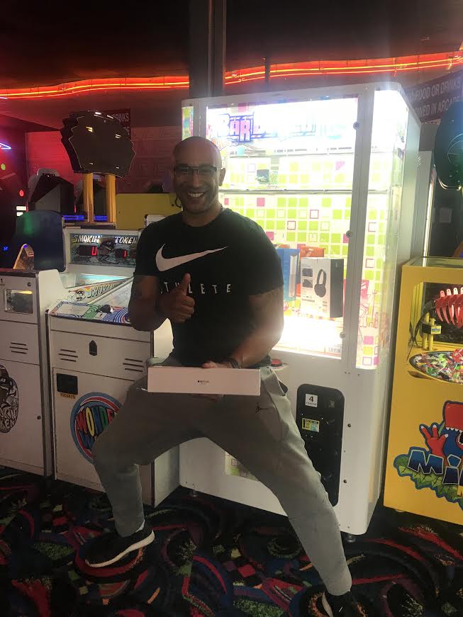 Man is happy with his time at the arcade. He has had some good quality family fun. Today is a good day.
